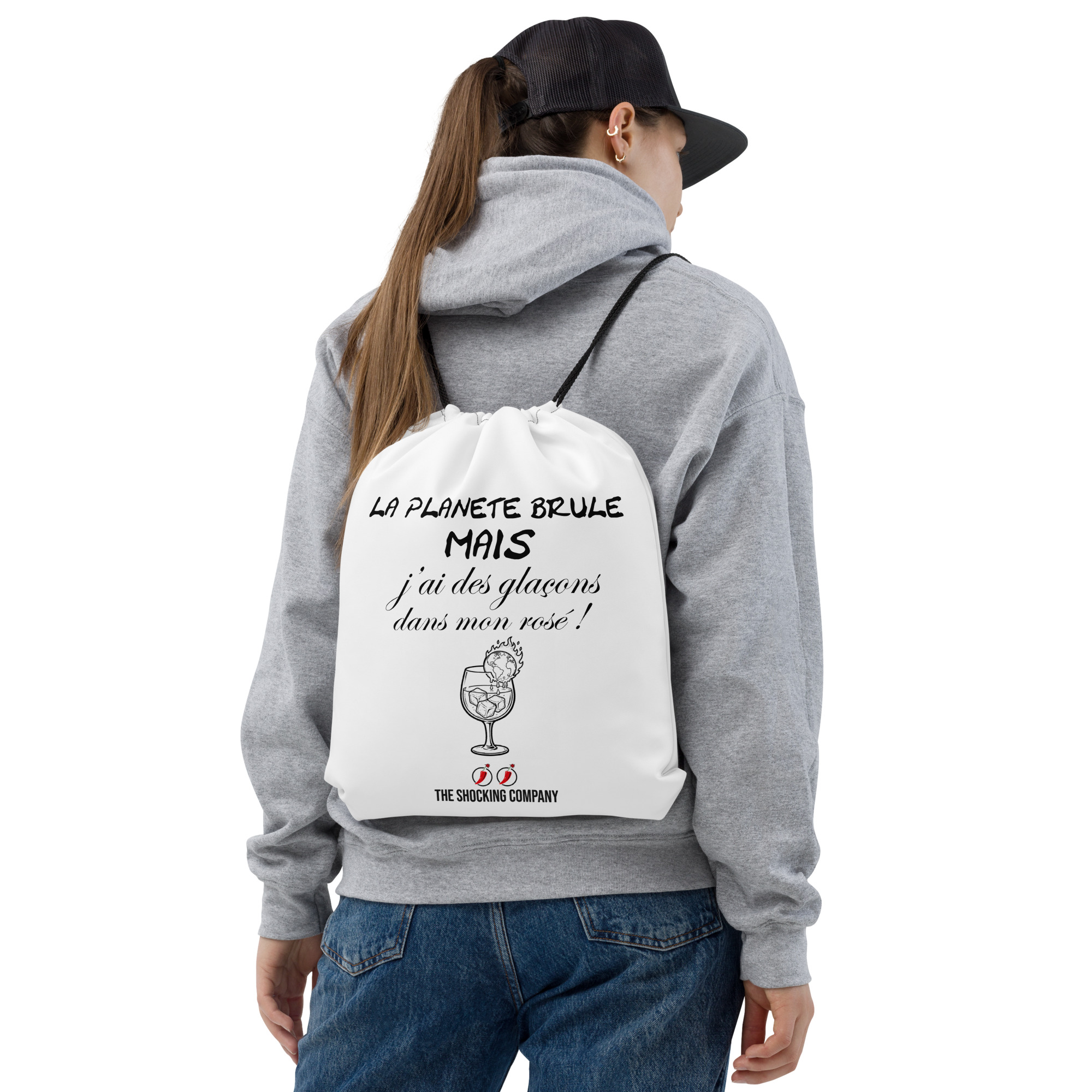 Sac à cordons blanc avec design noir montrant la phrase « La planète brûle mais j’ai des glaçons dans mon rosé ! » et une planète en flammes dans un verre.