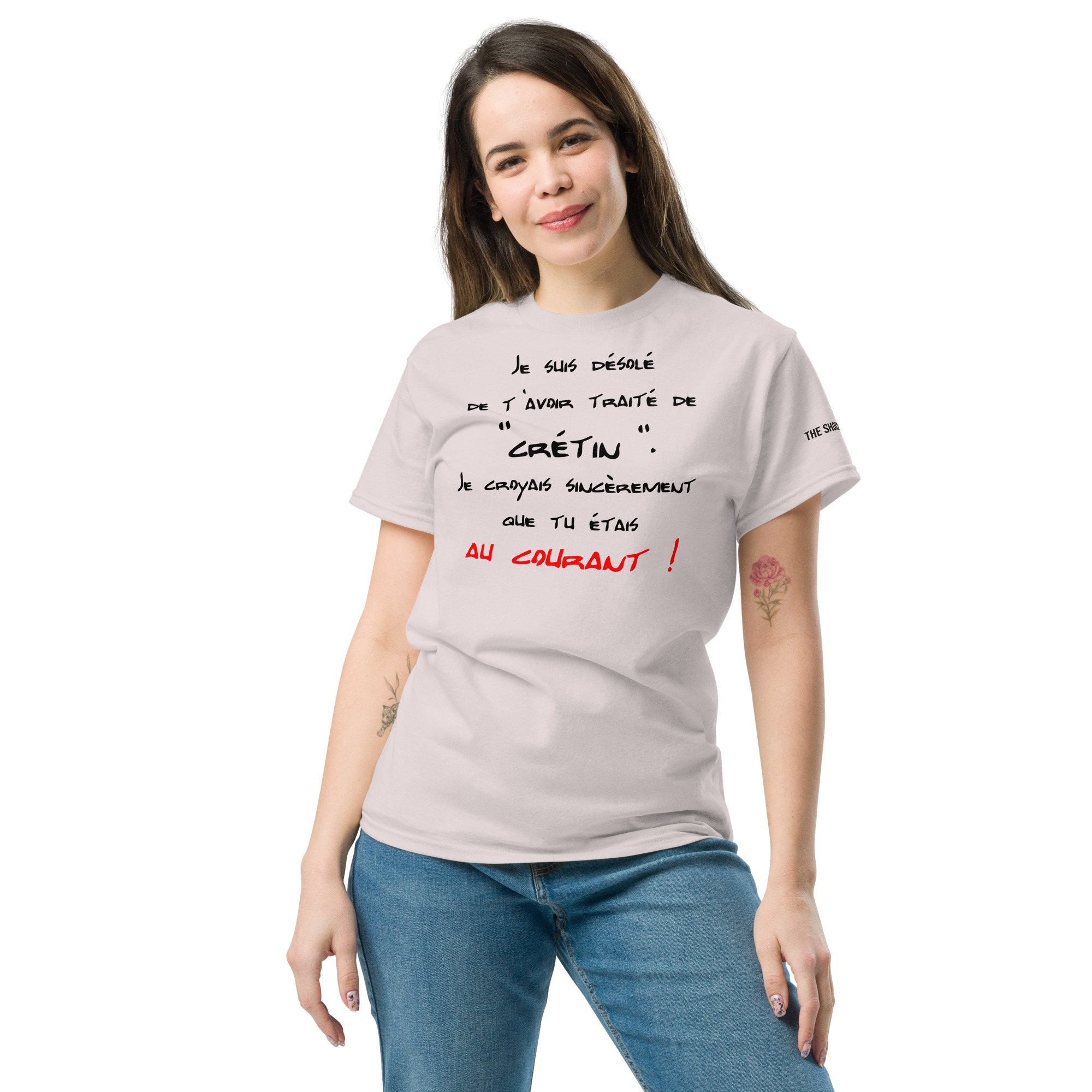 Modèle portant un t-shirt clair avec la punchline « désolé de t’avoir traité de crétin, je croyais que tu étais au courant ! » dans un style manuscrit sarcastique et passif-agressif.