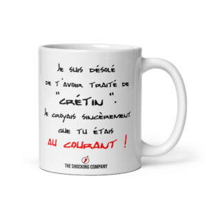 Mug blanc avec message sarcastique « Je suis désolé de t’avoir traité de crétin », en lettrage noir et chute « AU COURANT ! » en rouge.