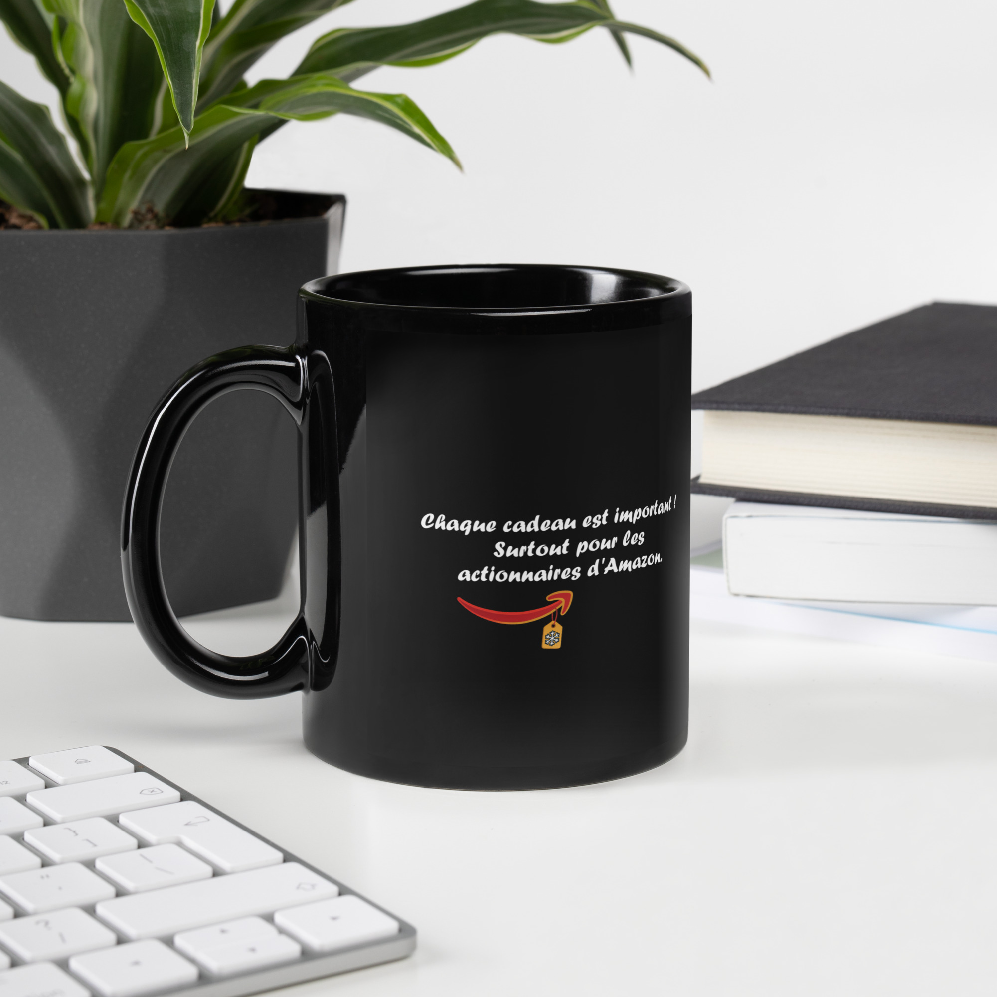 Tasse noire avec le message « Chaque cadeau est important ! Surtout pour les actionnaires d’Amazon. » en lettres blanches, accompagné d’un visuel inspiré de l’univers Amazon avec une petite étiquette cadeau.