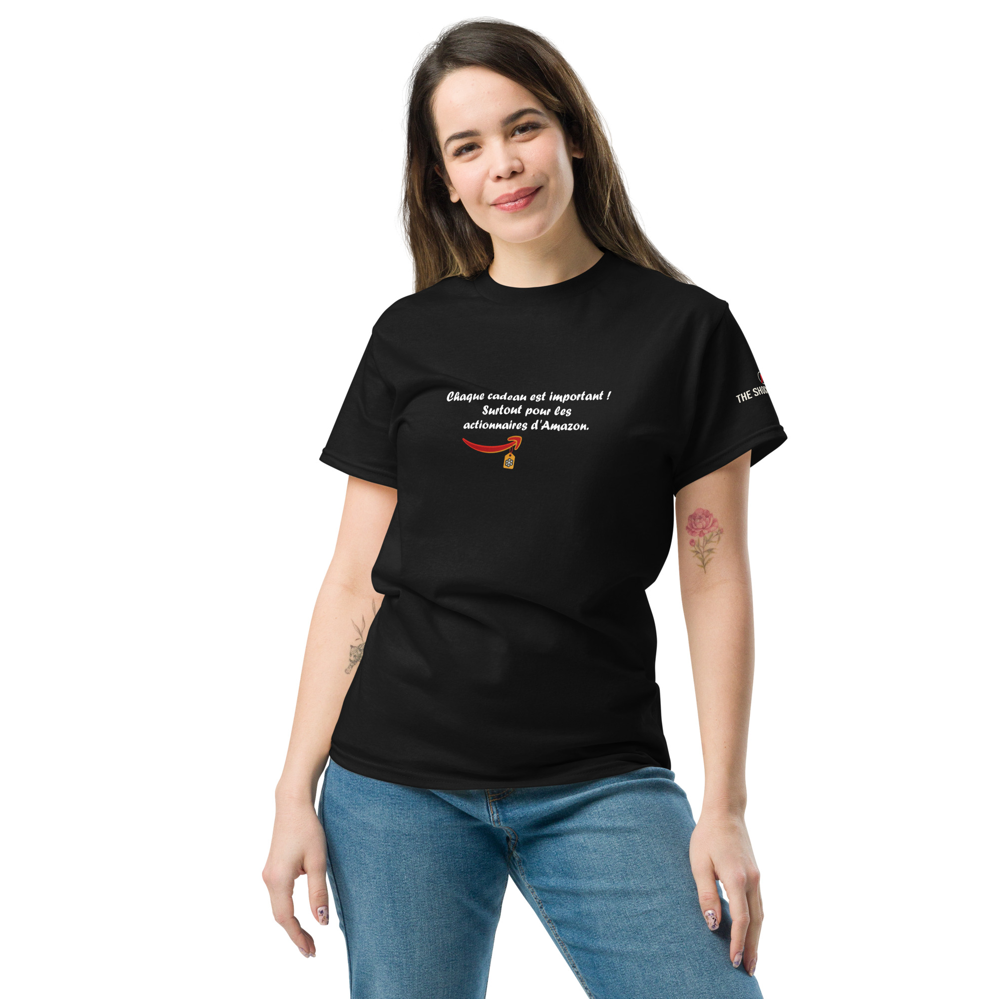 T-shirt col rond avec le message « Chaque cadeau est important ! Surtout pour les actionnaires d’Amazon. » en lettres blanches, accompagné d’un visuel évoquant Amazon et une étiquette cadeau.